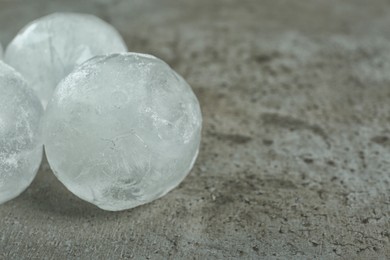 Photo of Frozen ice balls on grey table, closeup. Space for text