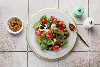 Photo of Delicious salad with vegetables, spinach and olives served on light table, flat lay