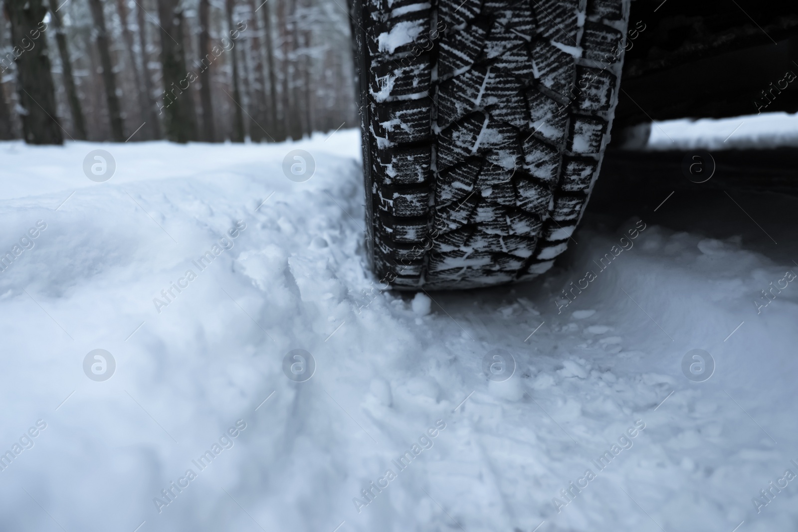 Photo of Snowy country road with car on winter day, closeup. Space for text