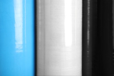 Photo of Rolls of different stretch wrap as background, closeup