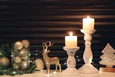 Burning candles and Christmas decor on white table