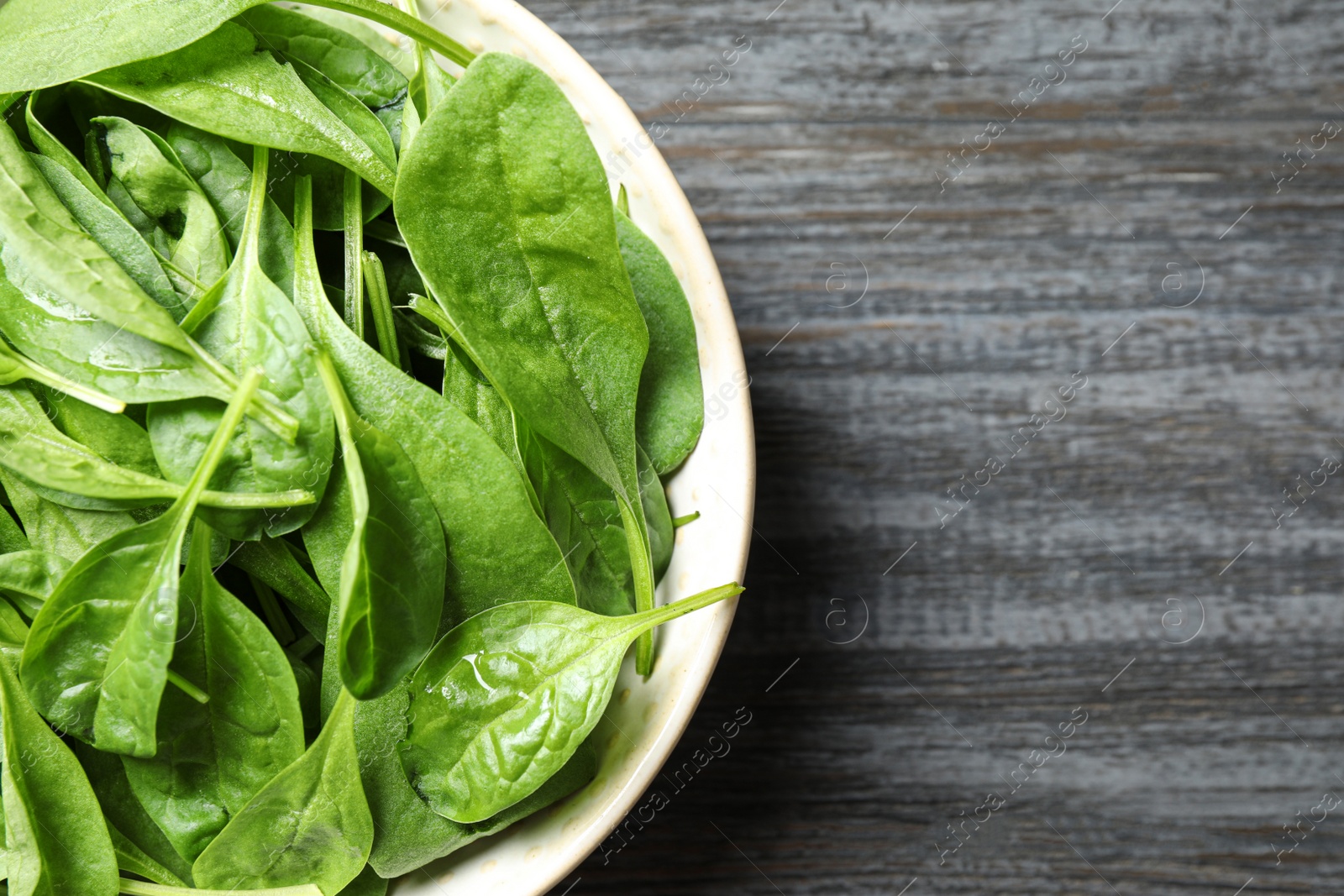 Photo of Fresh green healthy spinach on dark wooden table, top view. Space for text