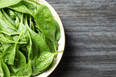 Photo of Fresh green healthy spinach on dark wooden table, top view. Space for text