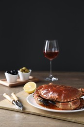 Photo of Delicious crab with lemon served on wooden table