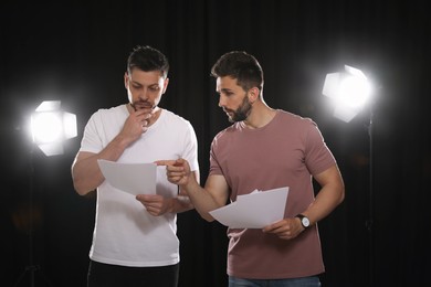 Photo of Professional actors reading their scripts during rehearsal in theatre