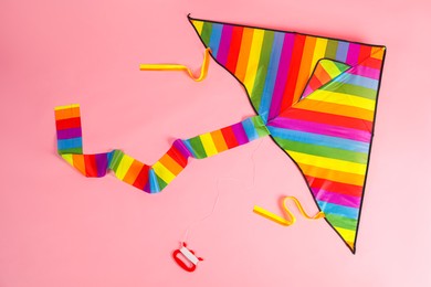 Photo of Bright rainbow kite on pink background, top view