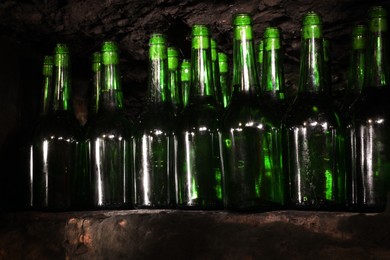 Photo of Many bottles of alcohol drinks on shelf in cellar