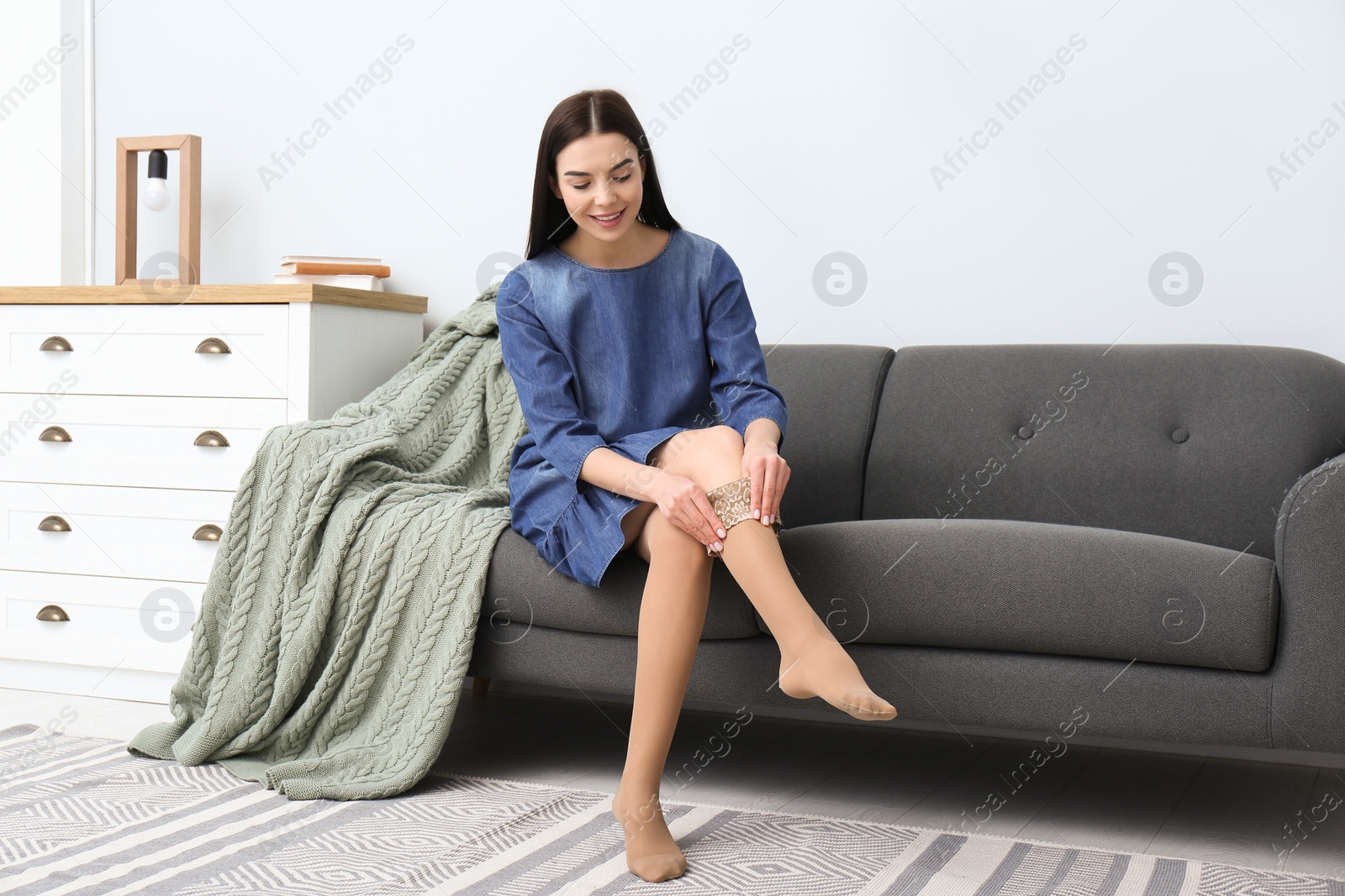 Photo of Woman wearing compression tights in living room. Space for text