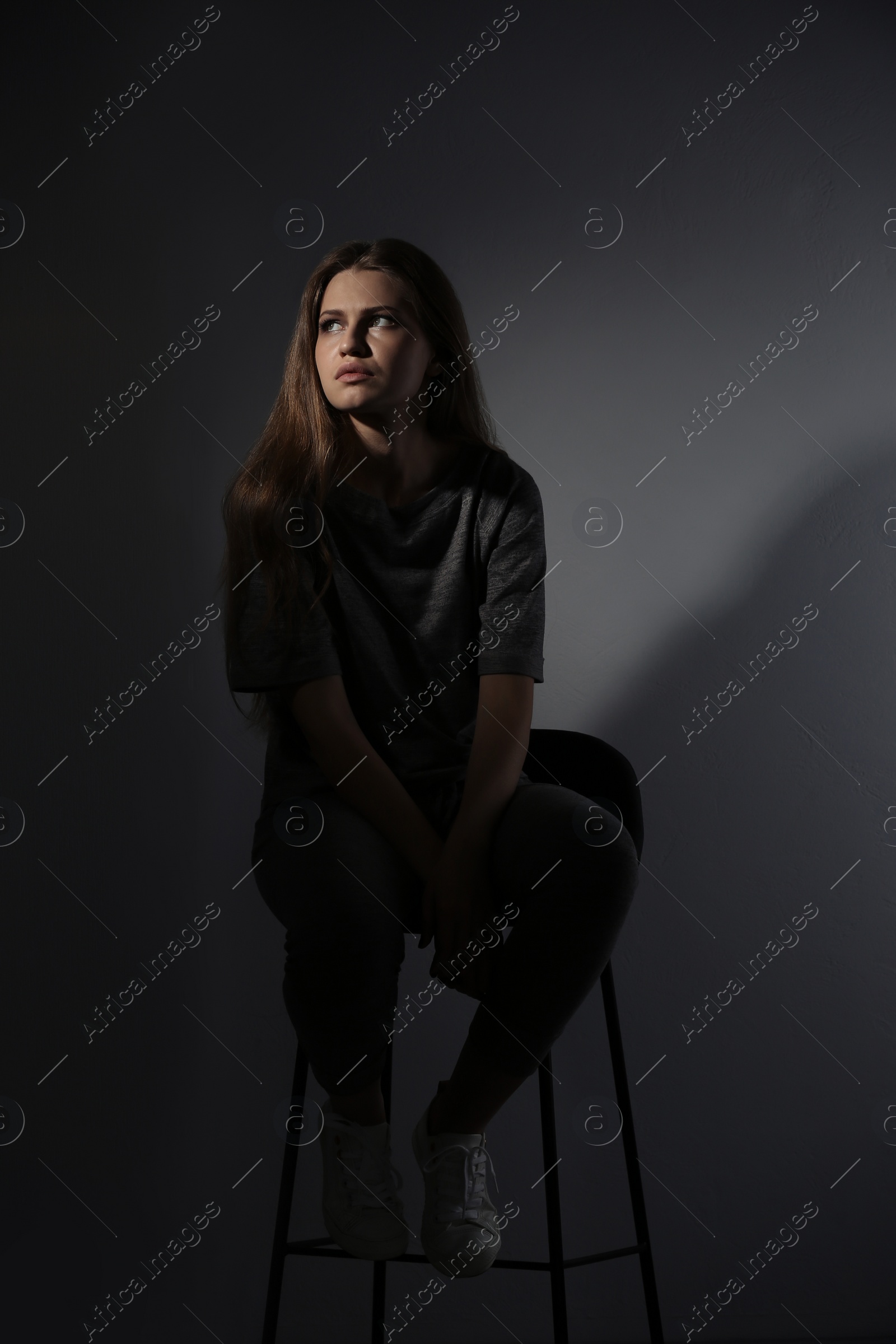 Photo of Depressed young woman on gray background