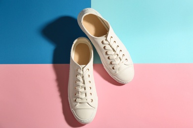 Photo of Pair of stylish sneakers on color background, top view