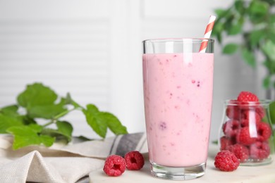 Photo of Glass of tasty raspberry smoothie on light table, space for text