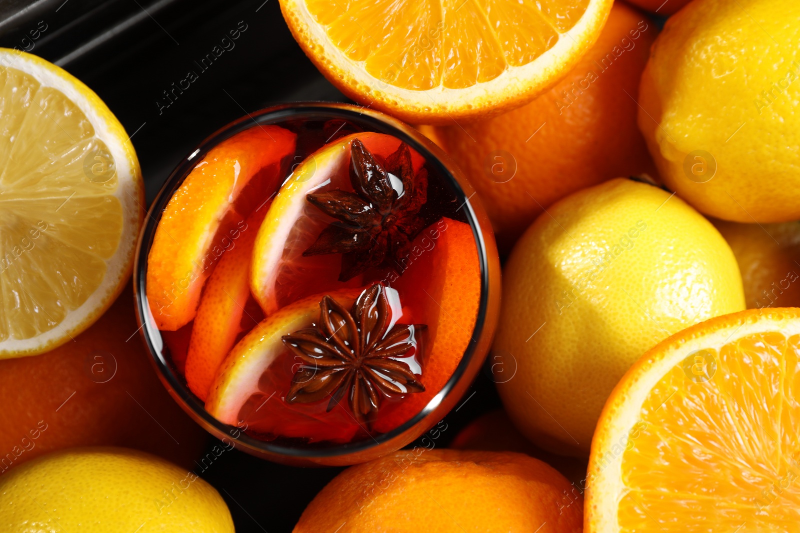 Photo of Glass of aromatic punch drink and fresh citrus fruits on table, flat lay