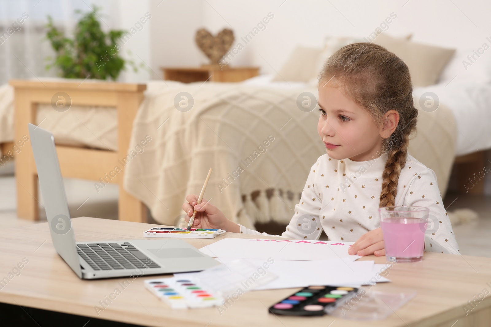 Photo of Little girl learning to paint with online course at home. Space for text