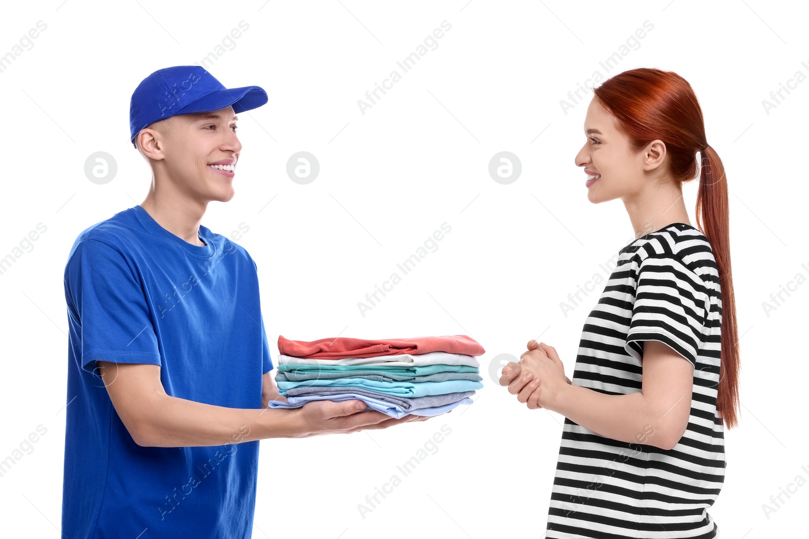 Image of Dry-cleaning delivery. Courier giving folded clothes to woman on white background