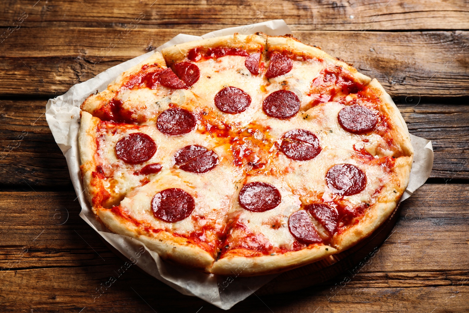 Photo of Hot delicious pepperoni pizza on wooden table