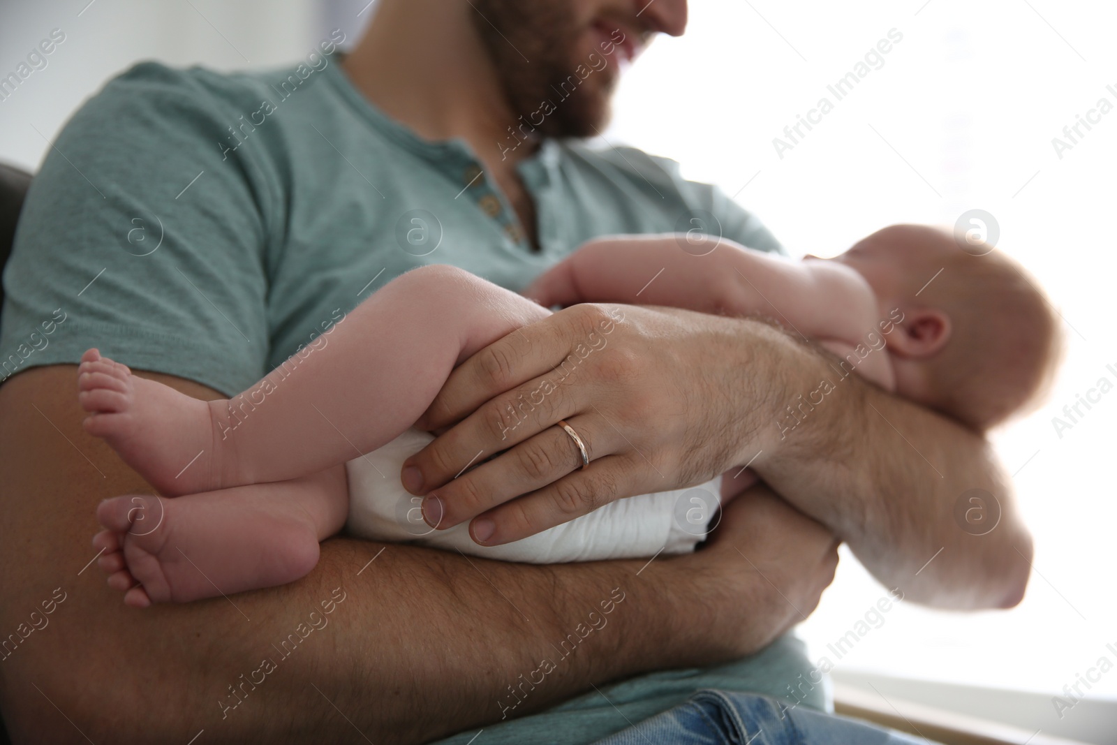 Photo of Father with his newborn son at home, closeup