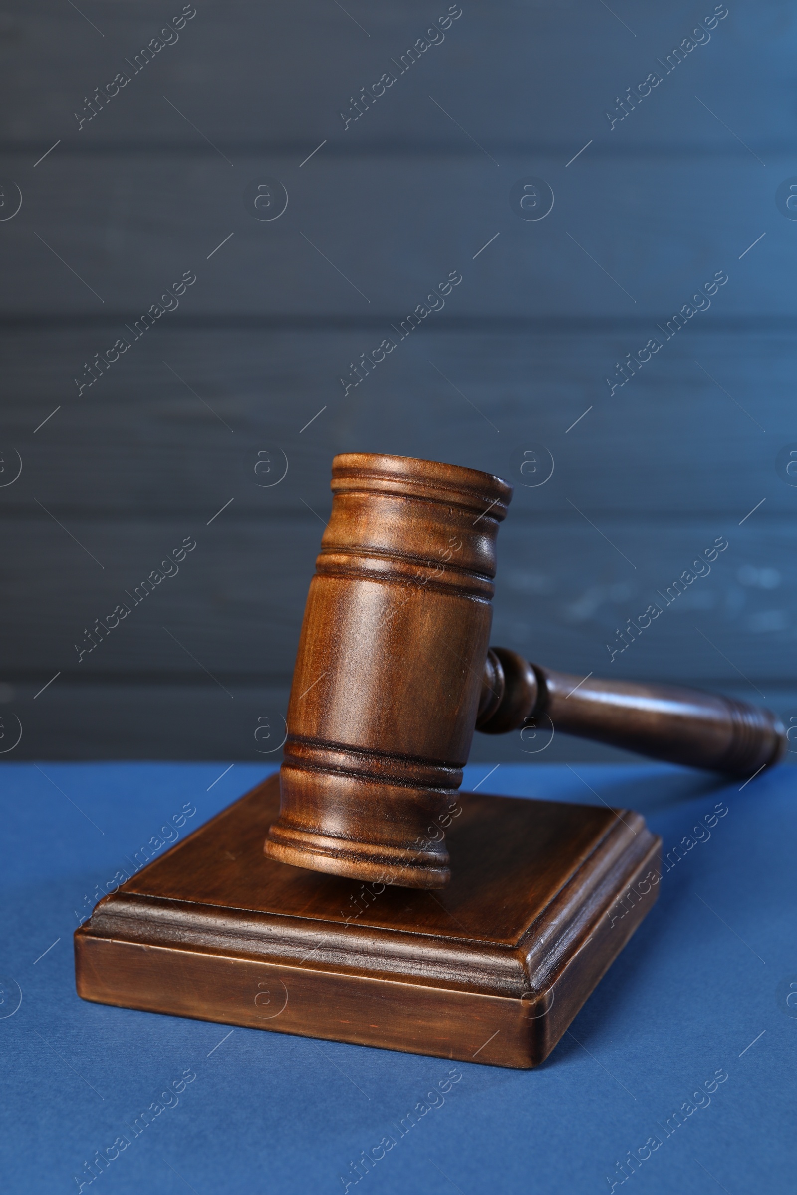 Photo of Wooden gavel on blue table. Space for text