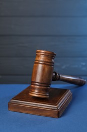 Photo of Wooden gavel on blue table. Space for text