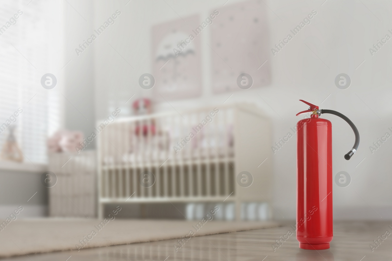 Image of Fire extinguisher on floor in baby room. Space for text