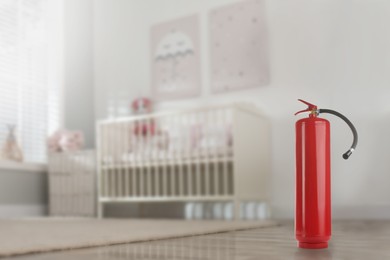 Fire extinguisher on floor in baby room. Space for text