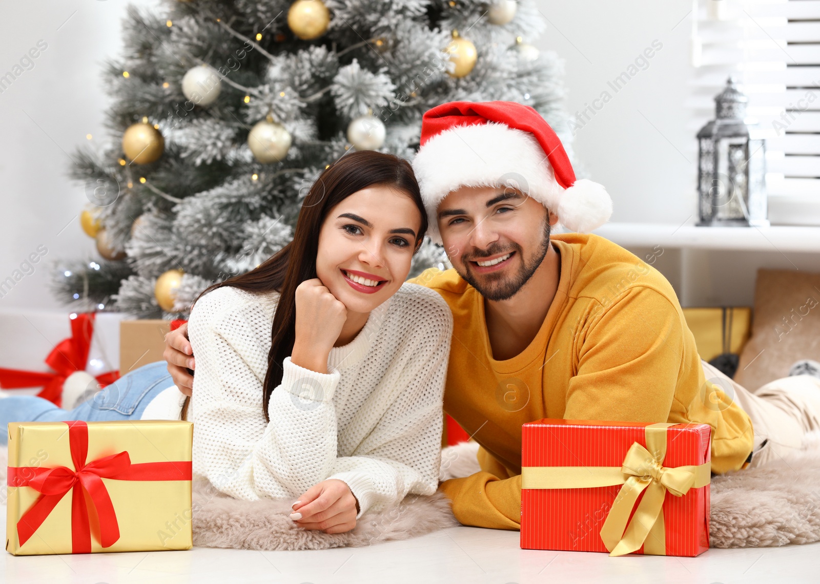 Photo of Happy young couple with Christmas gifts at home