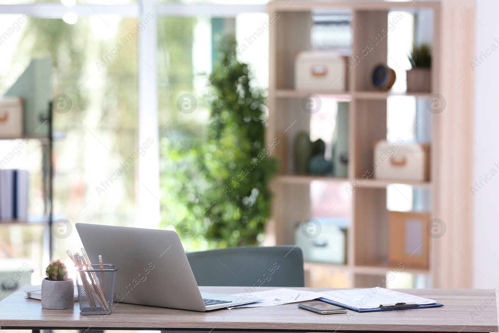 Photo of Comfortable workplace with modern laptop on desk in office