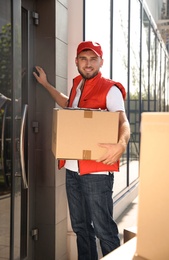Photo of Male mover with parcel box near entrance