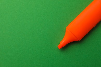 Photo of Bright orange marker on green background, top view. Space for text