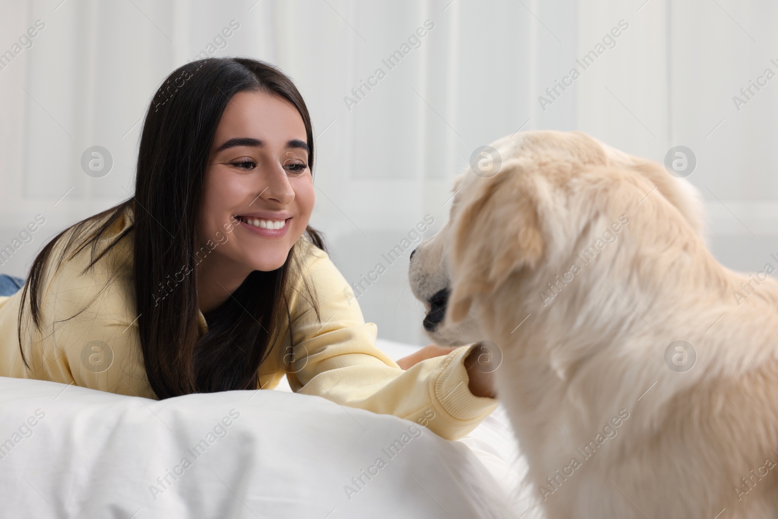 Photo of Happy woman with cute Labrador Retriever dog at home. Adorable pet