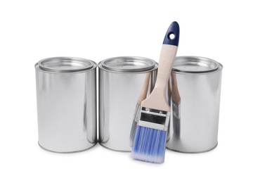 Cans of paints and brush on white background