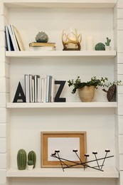 Photo of Many shelves with different decor in room. Interior design