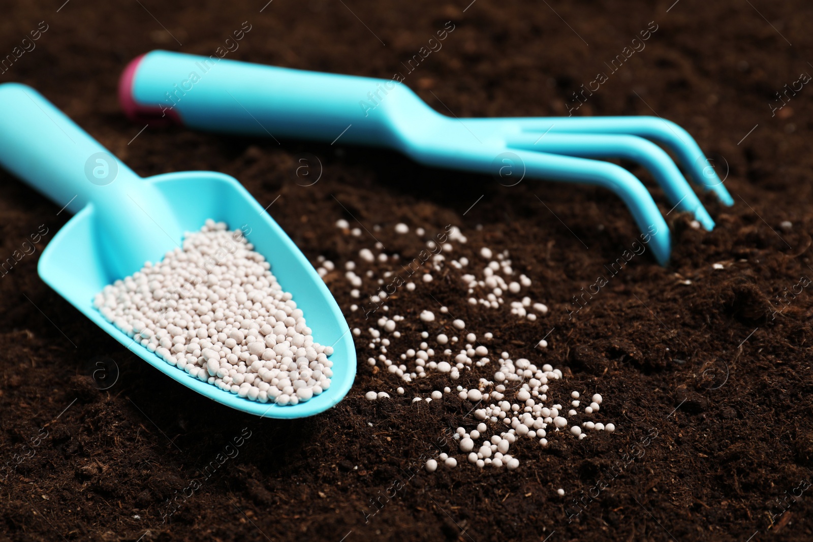 Photo of Gardening tools and chemical fertilizer on soil