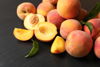 Photo of Pile of delicious ripe peaches on wooden table, closeup