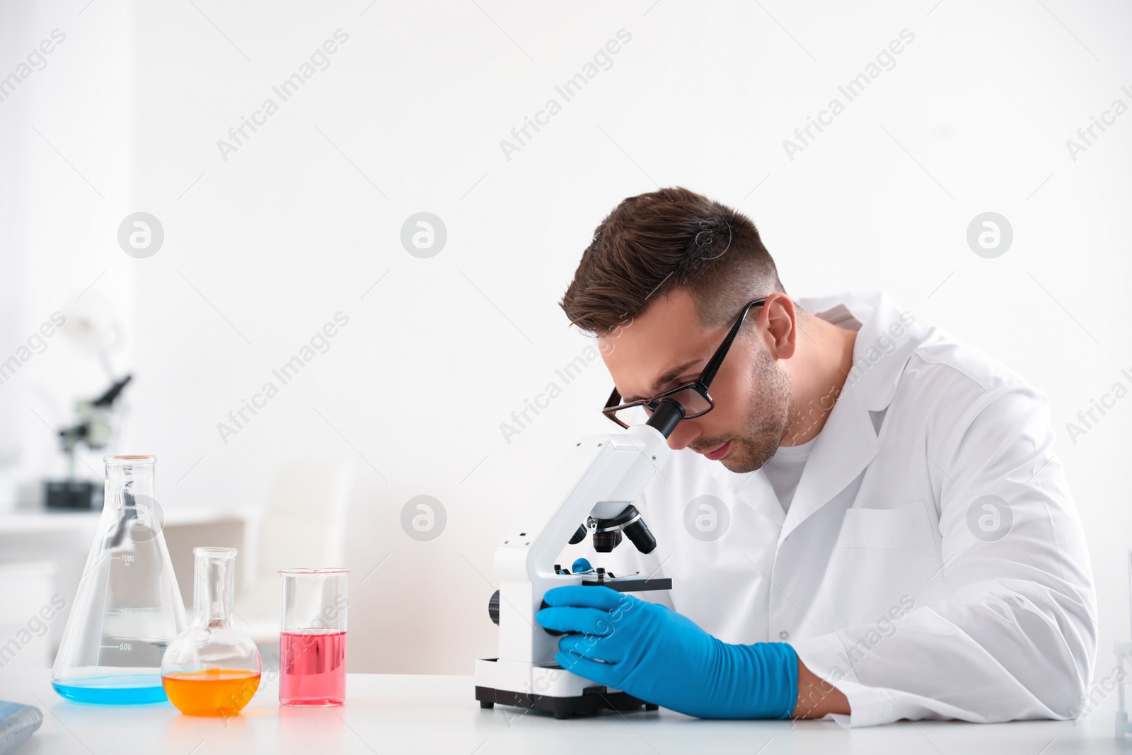 Photo of Scientist using modern microscope at table. Medical research