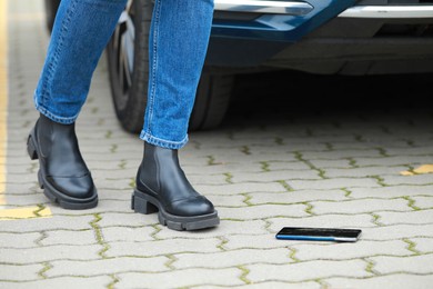 Woman near dropped smartphone on pavement, closeup. Device repairing