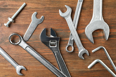 Photo of Auto mechanic's tools on wooden background, flat lay