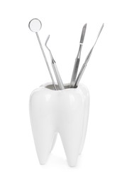Photo of Tooth shaped holder with dental tools on white background