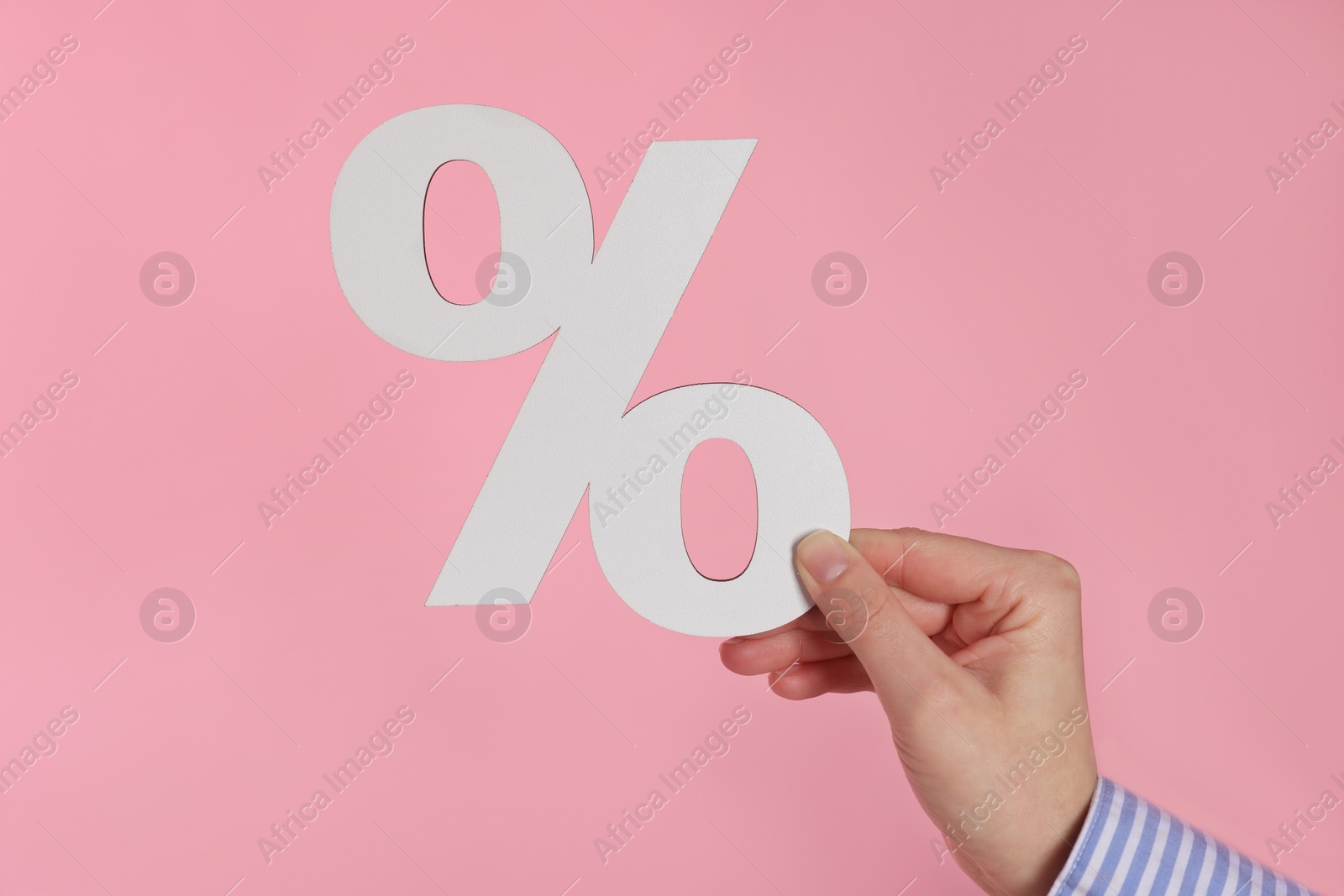 Photo of Woman holding percent sign on pink background, closeup