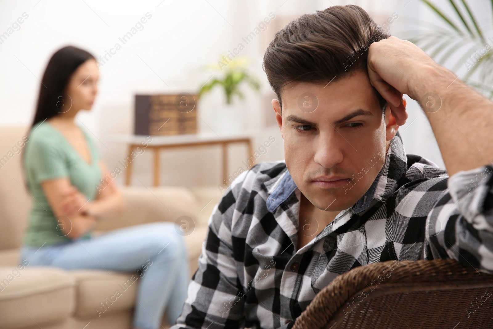 Photo of Unhappy man after quarrel with his girlfriend indoors. Relationship problems
