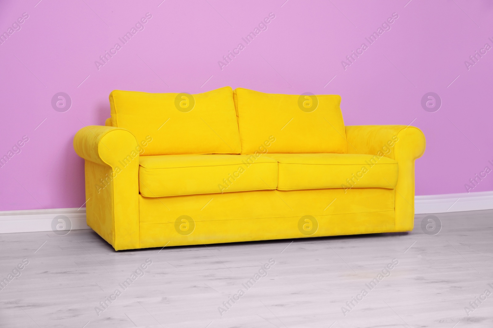 Photo of Room interior with comfortable sofa near color wall