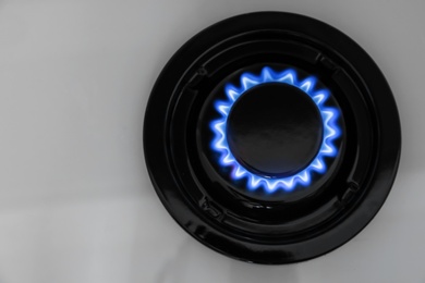Gas burner of modern stove with burning blue flame, top view