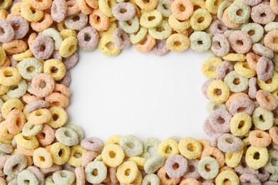 Photo of Frame made of tasty cereal rings on white background, top view. Space for text