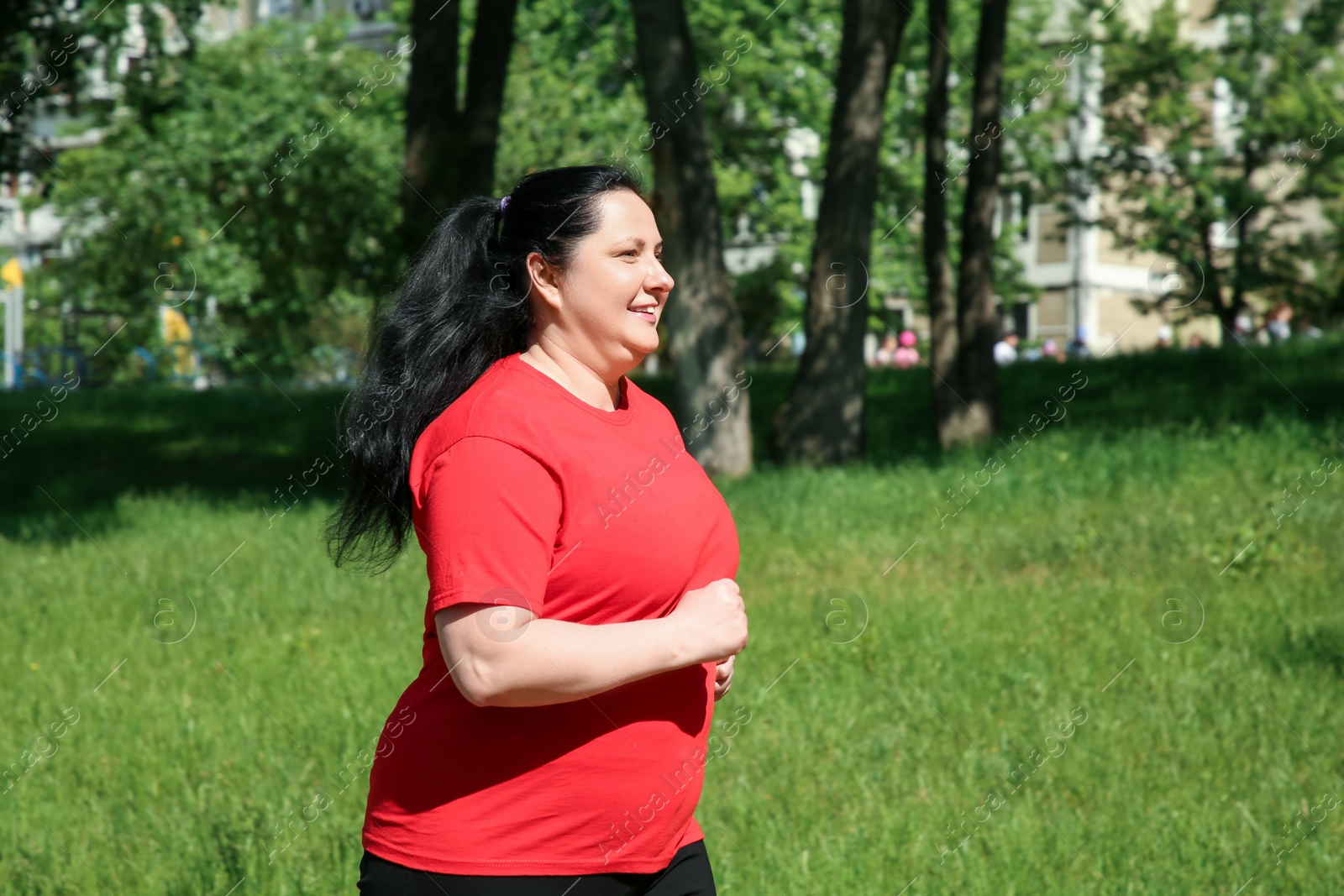 Photo of Overweight woman jogging in park on sunny day