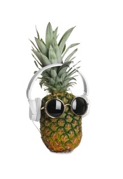 Photo of Funny pineapple with headphones and sunglasses on white background