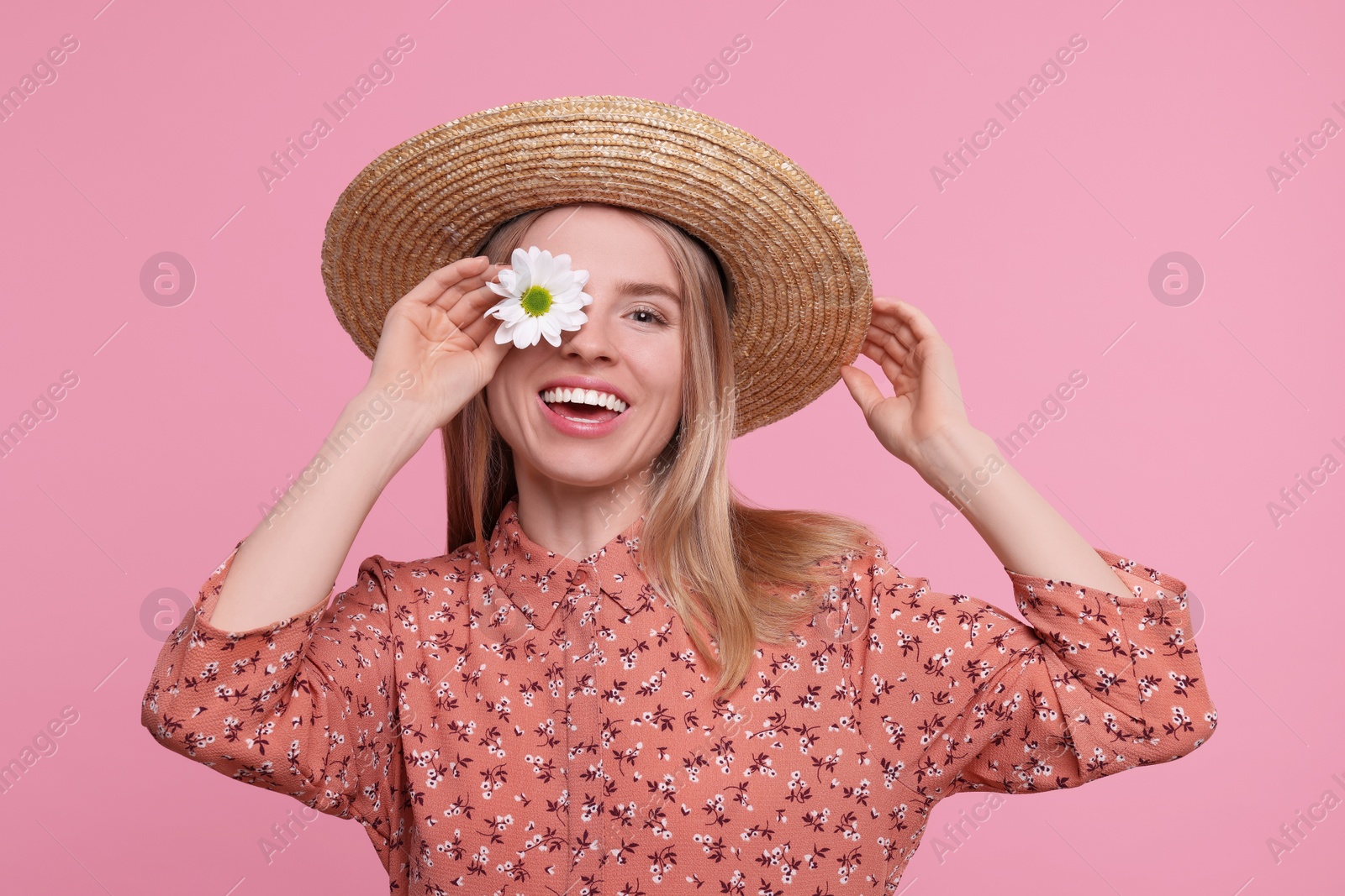 Photo of Beautiful woman with spring flower in hand on pink background