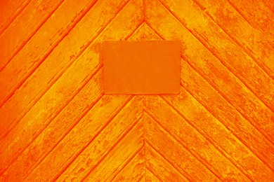 Image of Textured orange wooden surface with stained signboard as background