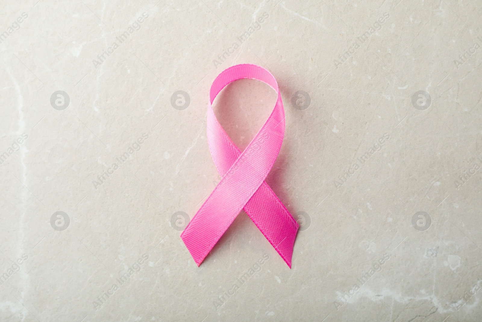 Photo of Pink ribbon on grey background, top view. Breast cancer awareness concept