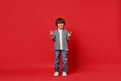 Happy little boy dancing on red background