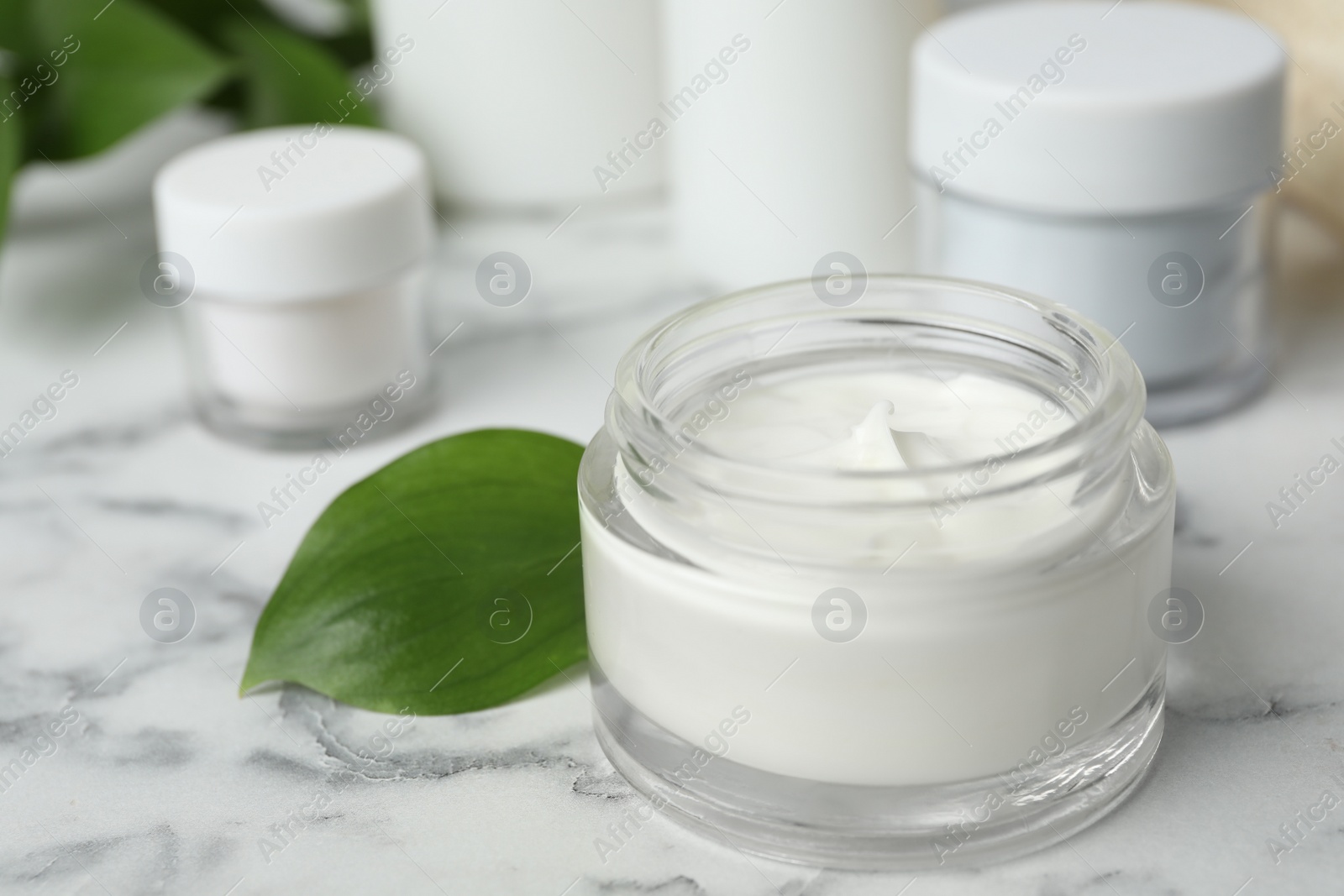 Photo of Jar of body care product on marble table. Space for text