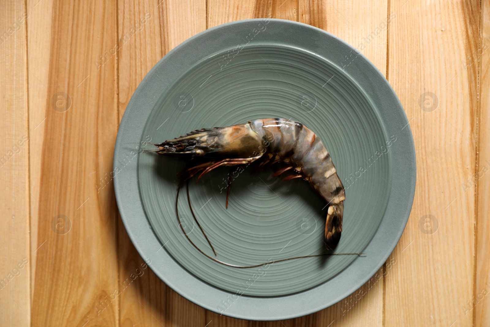 Photo of Fresh black tiger shrimp on wooden table, top view